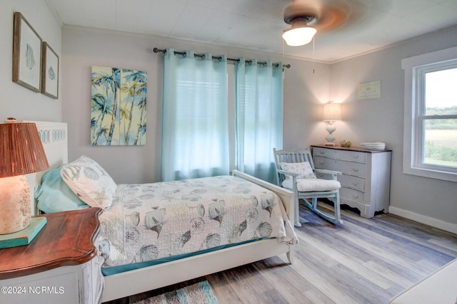 bedroom with baseboards, a ceiling fan, wood finished floors, and ornamental molding