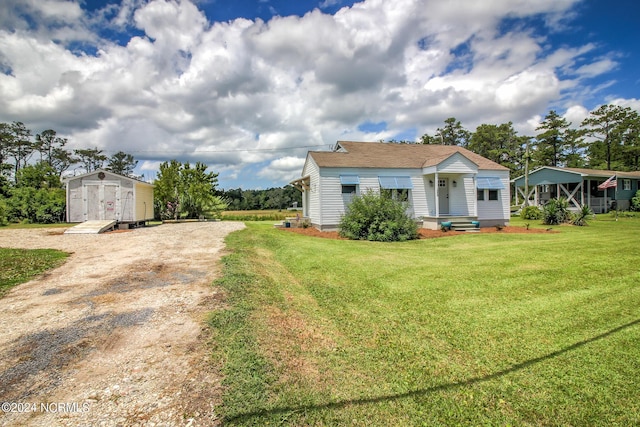 view of front of property with an outbuilding, a storage shed, and a front yard