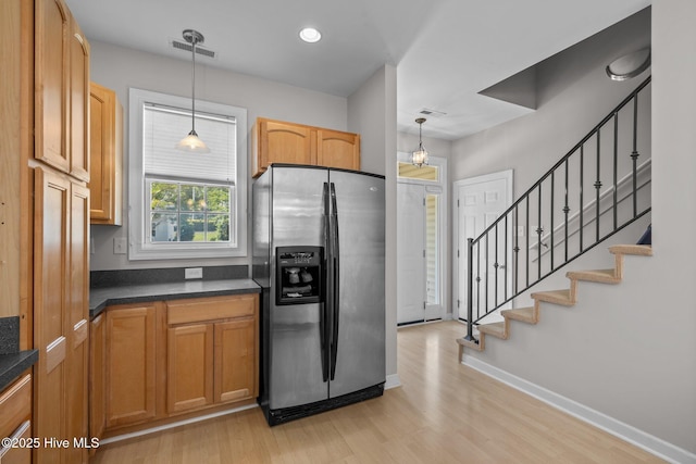 512 Village Green Dr Unit A, Morehead City, NC 28557 - kitchen featuring stainless steel fridge with ice dispenser, dark countertops, light wood finished floors, and hanging light fixtures