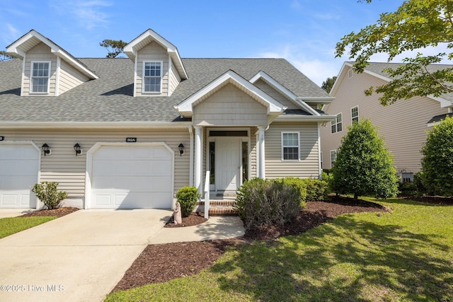 512 Village Green Dr Unit A, Morehead City, NC 28557 - new england style home featuring roof with shingles, a front yard, concrete driveway, and an attached garage