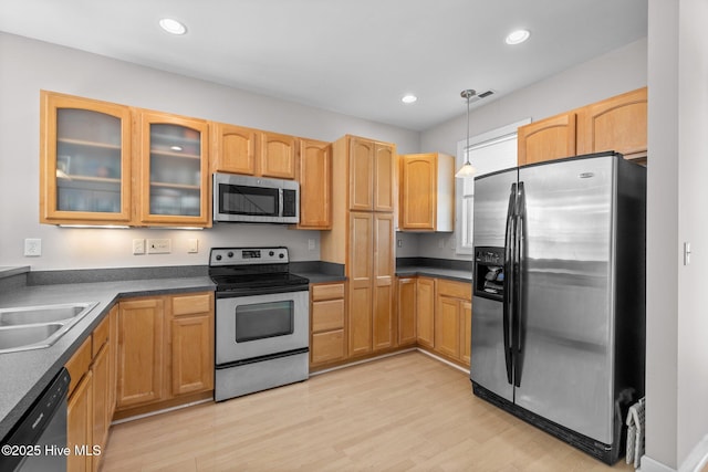 512 Village Green Dr Unit A, Morehead City, NC 28557 - kitchen featuring appliances with stainless steel finishes, a sink, glass insert cabinets, dark countertops, and pendant lighting