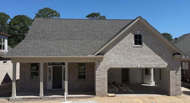 457 Motts Forest Rd Unit 69, Wilmington, NC 28412 - view of front facade featuring roof with shingles, brick siding, a patio, a garage, and driveway
