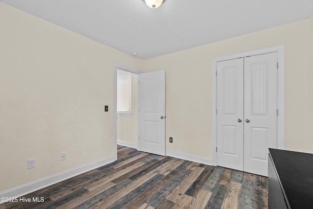 141 Trevor Way, Moyock, NC 27958 - unfurnished bedroom featuring a closet, dark wood-type flooring, and baseboards