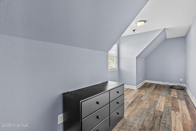 141 Trevor Way, Moyock, NC 27958 - additional living space with lofted ceiling, a textured wall, baseboards, and wood finished floors
