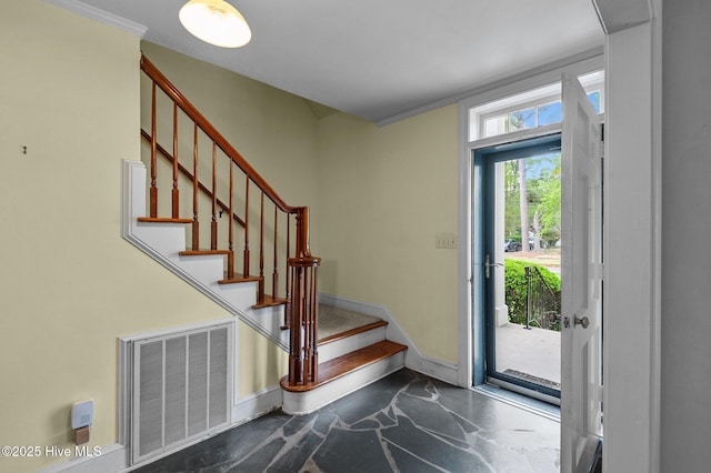 foyer with baseboards and stairs