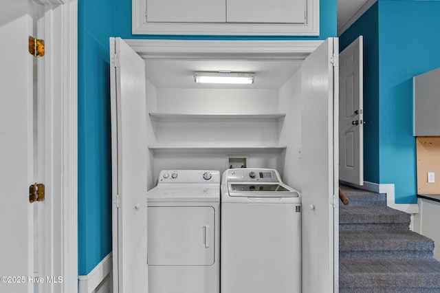 clothes washing area with separate washer and dryer and baseboards