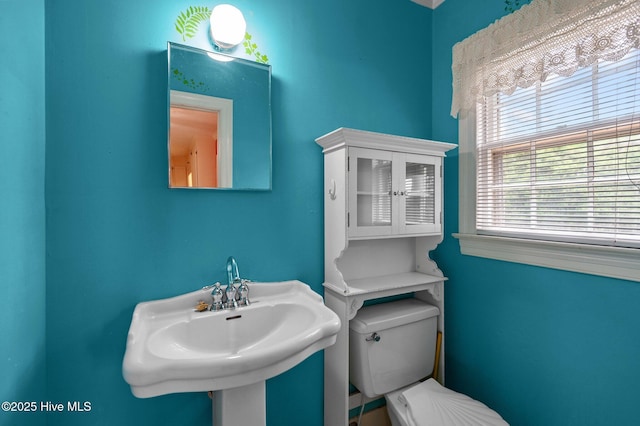 half bath with toilet and a sink