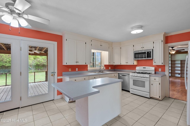 kitchen featuring appliances with stainless steel finishes, light countertops, a sink, a ceiling fan, and light tile patterned flooring