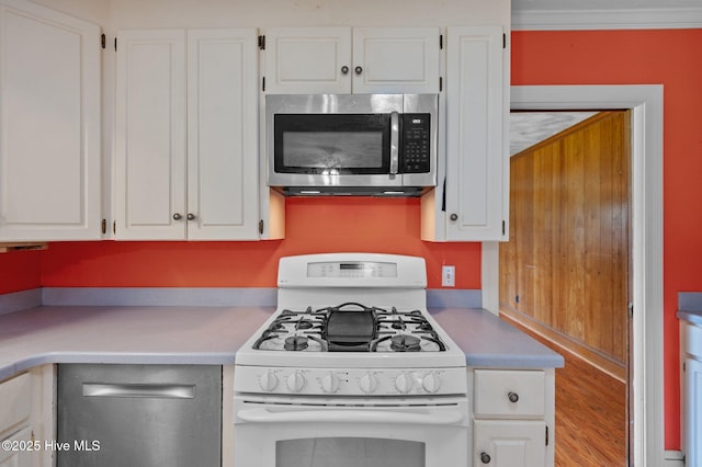 kitchen featuring stainless steel appliances, light countertops, white cabinetry, and wood finished floors