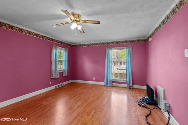 spare room with wood finished floors, ceiling fan, and baseboards