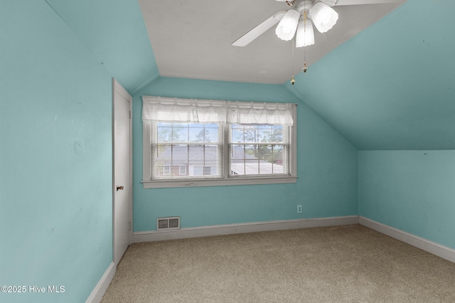 additional living space featuring vaulted ceiling, carpet flooring, a ceiling fan, and baseboards
