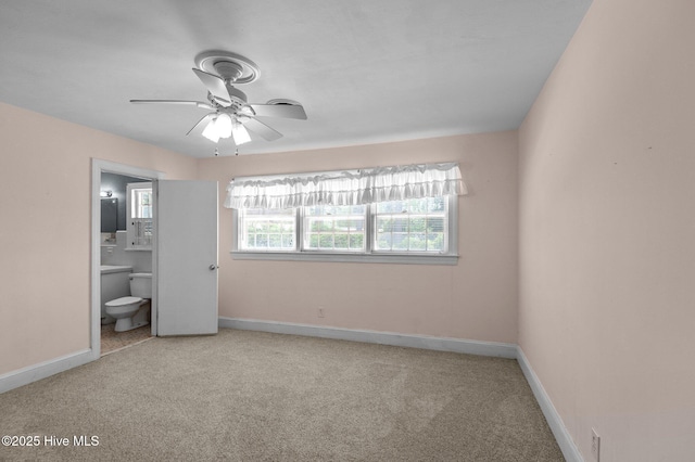 unfurnished bedroom featuring carpet, connected bathroom, baseboards, and ceiling fan