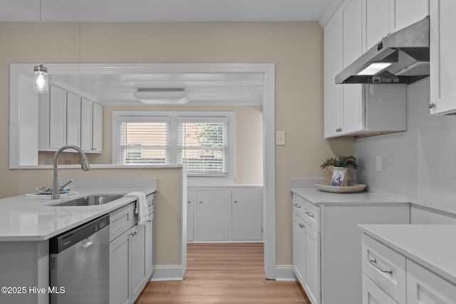 502 Thomas Ave, Wilmington, NC 28405 - kitchen featuring a sink, light countertops, under cabinet range hood, light wood finished floors, and stainless steel dishwasher