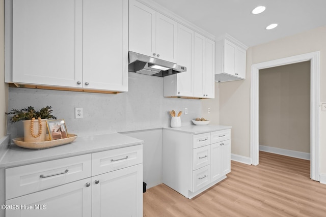 502 Thomas Ave, Wilmington, NC 28405 - kitchen with recessed lighting, light wood-style flooring, white cabinetry, light countertops, and under cabinet range hood