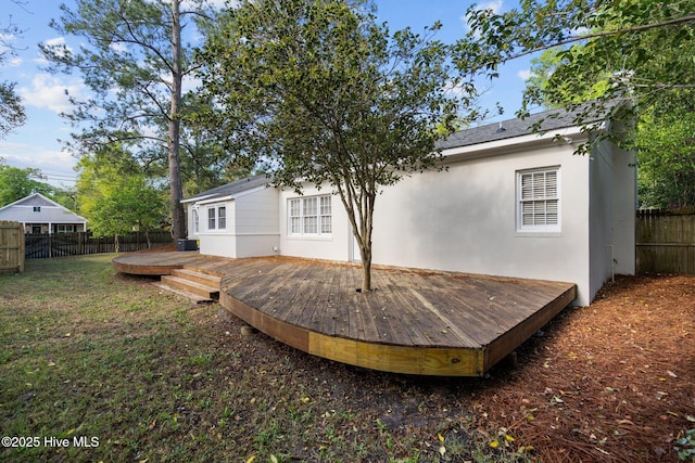 502 Thomas Ave, Wilmington, NC 28405 - back of house with a fenced backyard, stucco siding, a wooden deck, and a lawn