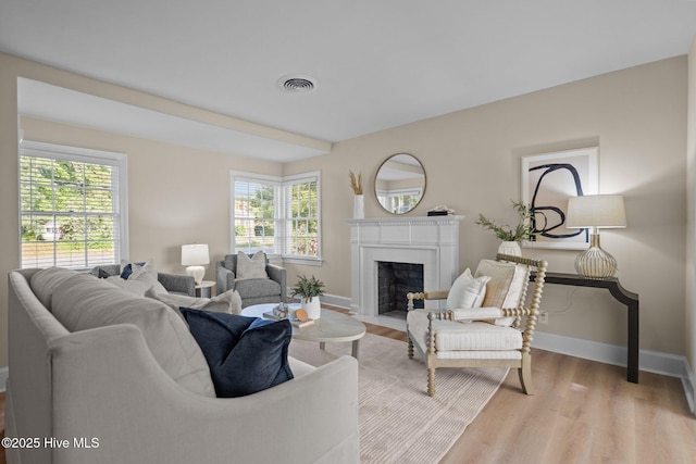 502 Thomas Ave, Wilmington, NC 28405 - living room featuring a fireplace with flush hearth, light wood finished floors, baseboards, and visible vents