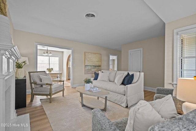 502 Thomas Ave, Wilmington, NC 28405 - living room featuring wood finished floors, an inviting chandelier, baseboards, and visible vents