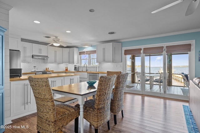 dining room with light wood-style floors, ceiling fan, ornamental molding, visible vents, and recessed lighting