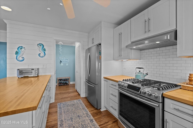 kitchen with wooden counters, a toaster, appliances with stainless steel finishes, backsplash, and under cabinet range hood