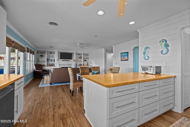 kitchen featuring visible vents, dishwasher, ceiling fan, crown molding, and wood counters
