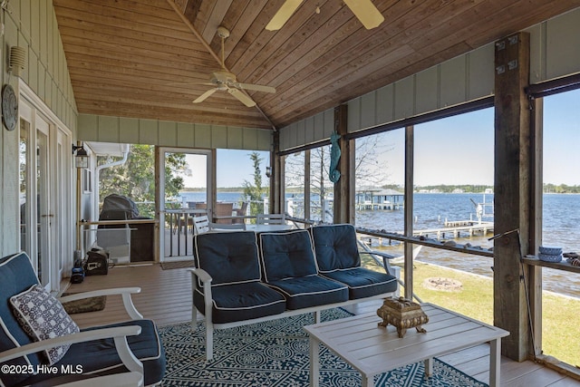 sunroom featuring a water view and ceiling fan