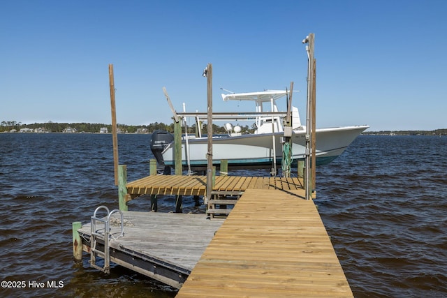 dock area featuring boat lift and a water view