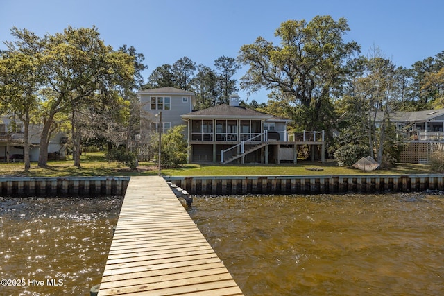 view of dock with a deck with water view, a lawn, and stairway