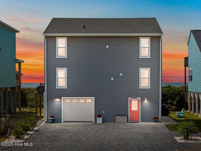 rear view of house featuring driveway and a garage