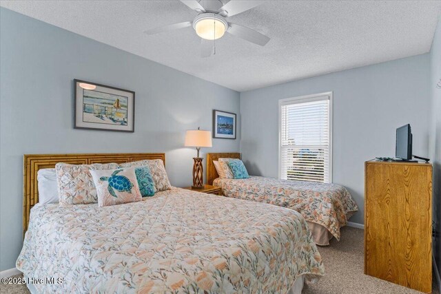 2709 W Beach Dr, Oak Island, NC 28465 - carpeted bedroom with baseboards, ceiling fan, and a textured ceiling