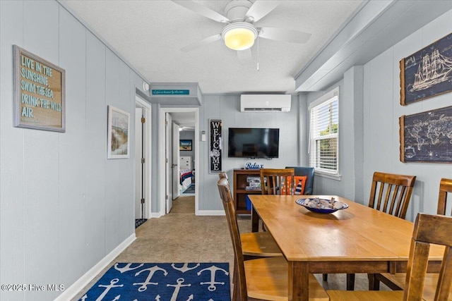 2709 W Beach Dr, Oak Island, NC 28465 - dining area featuring baseboards, ceiling fan, a wall unit AC, and a textured ceiling