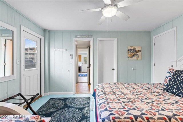 bedroom featuring ceiling fan, a wall mounted AC, a decorative wall, and visible vents