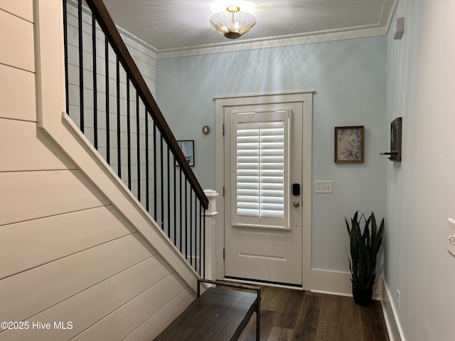 entryway featuring baseboards, wood finished floors, stairs, and crown molding