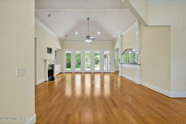 unfurnished living room featuring crown molding, ceiling fan, a wealth of natural light, and a fireplace