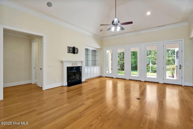 unfurnished living room with built in features, a fireplace with flush hearth, baseboards, a ceiling fan, and light wood-style flooring