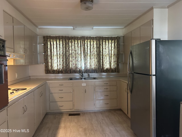 500 Rowan Rd, Clinton, NC 28328 - kitchen featuring freestanding refrigerator, a sink, light countertops, light wood-type flooring, and white electric stovetop