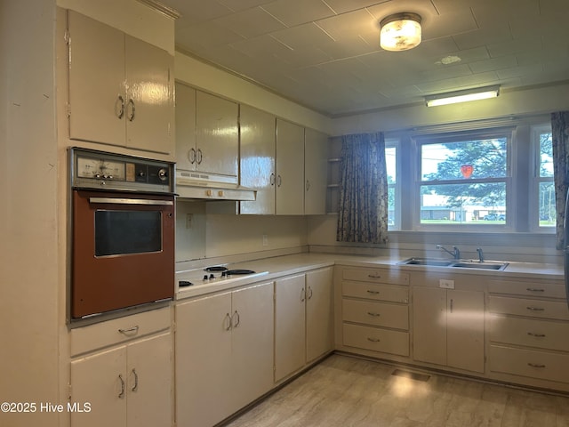 500 Rowan Rd, Clinton, NC 28328 - kitchen with wall oven, a sink, white electric cooktop, under cabinet range hood, and light countertops