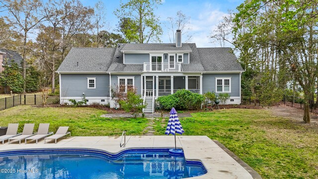 back of property with a balcony, a fenced backyard, and crawl space
