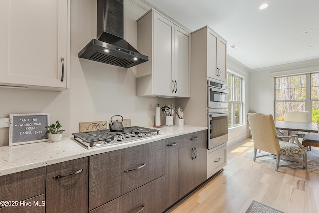 392 Blossom Tree Ln SE, Bolivia, NC 28422 - kitchen with wall chimney range hood, light wood-type flooring, light stone counters, and stainless steel appliances