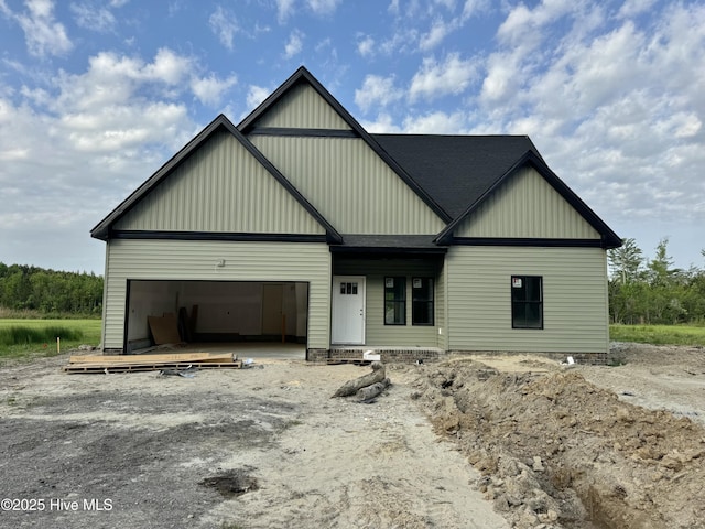 view of front of property featuring a garage, board and batten siding, and roof with shingles