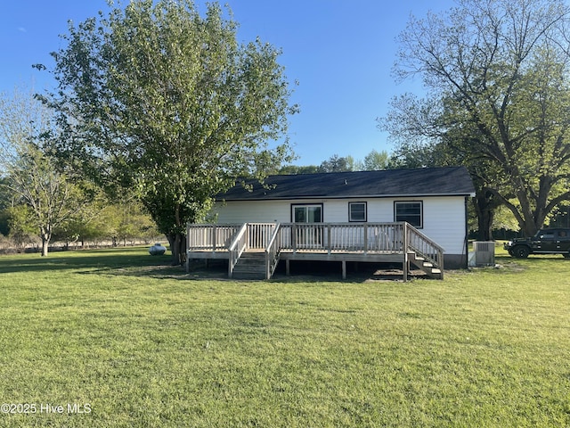 rear view of property with cooling unit, a yard, and a wooden deck