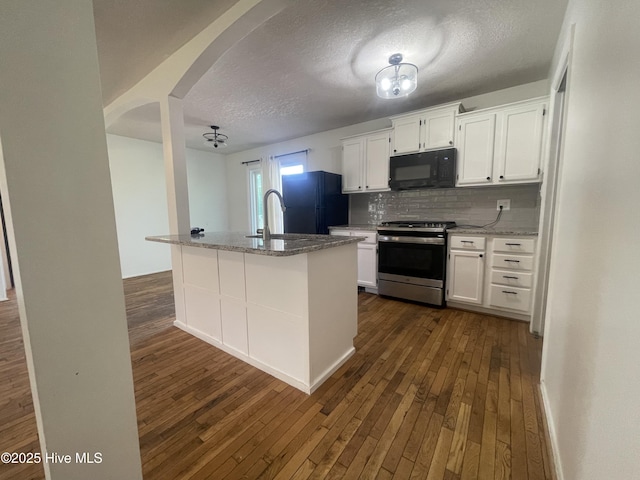 kitchen featuring white cabinets, arched walkways, dark wood-style flooring, and black appliances