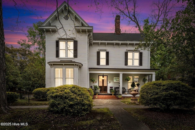 311 E Church St, Tarboro, NC 27886 - back of house at dusk featuring covered porch and a chimney