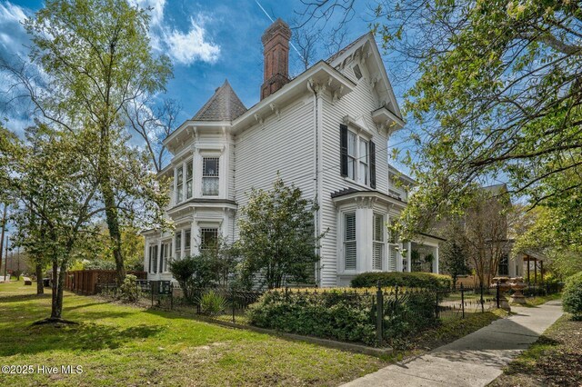 311 E Church St, Tarboro, NC 27886 - view of property exterior with a yard, a chimney, and a fenced front yard