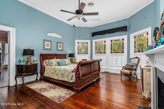 311 E Church St, Tarboro, NC 27886 - bedroom featuring a fireplace with flush hearth, wood-type flooring, visible vents, and ornamental molding