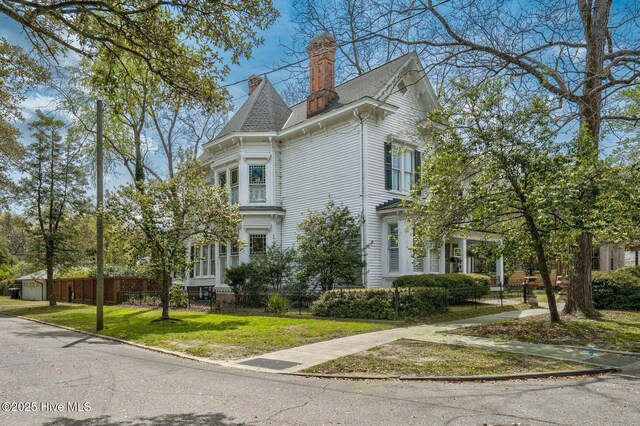 311 E Church St, Tarboro, NC 27886 - view of property exterior featuring a chimney, a shingled roof, fence, and a yard