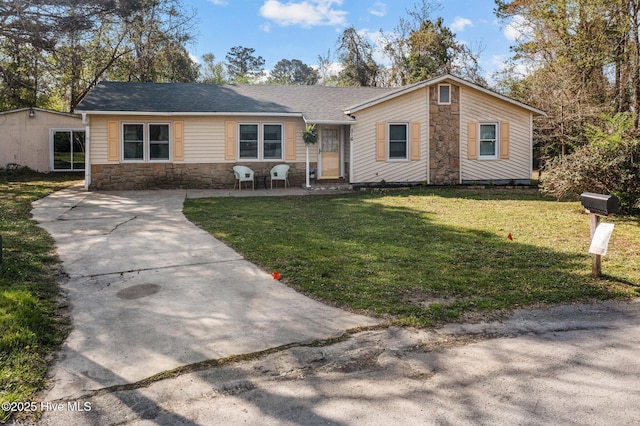 view of front of house with stone siding, driveway, and a front lawn