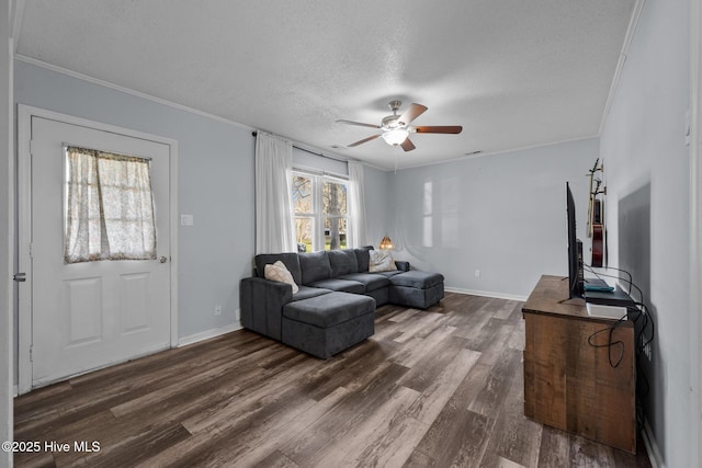living room with ornamental molding, ceiling fan, and dark wood-type flooring
