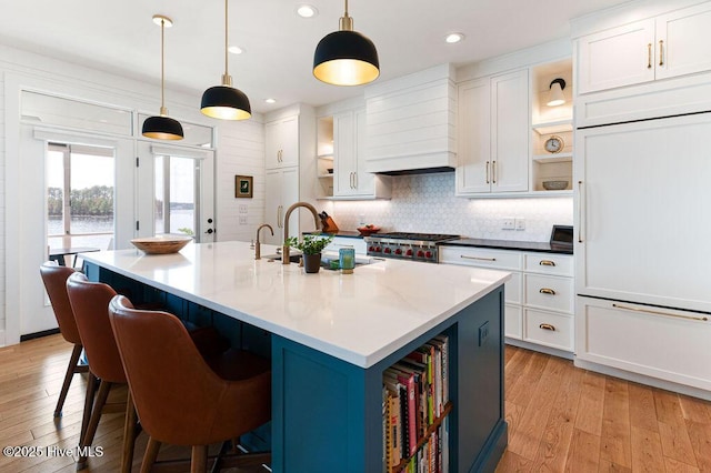 kitchen with white cabinetry, light wood-style floors, open shelves, and a sink