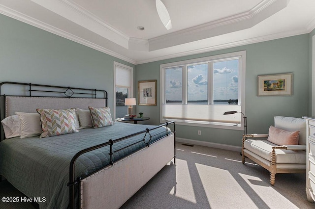 bedroom featuring a tray ceiling, visible vents, baseboards, dark colored carpet, and ornamental molding