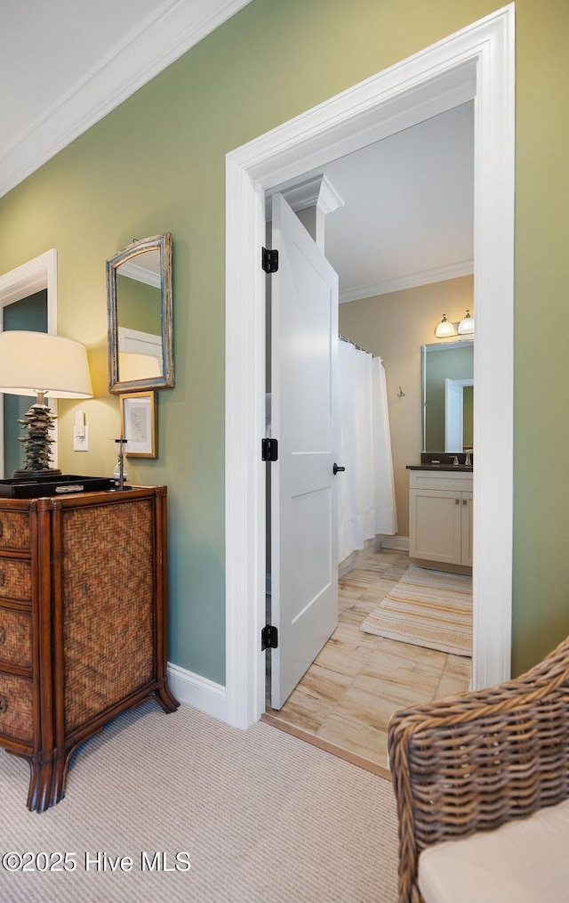 hallway featuring crown molding and baseboards
